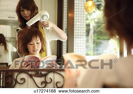 Stock Photo - Hairdresser drying woman's hair. Fotosearch
