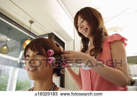 Hairdresser putting curlers in customer's hair View Large Photo Image Stock Image - Hairdresser putting curlers in customer's hair. Fotosearch