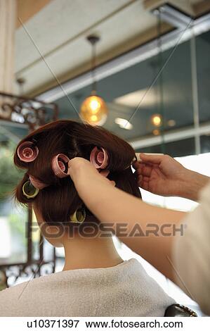 Hairdresser putting curlers in customer's hair View Large Photo Image Stock Photo - Hairdresser putting curlers in customer's hair. Fotosearch
