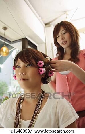 Hairdresser putting curlers in customer's hair View Large Photo Image Stock Photo - Hairdresser putting curlers in customer's hair. Fotosearch
