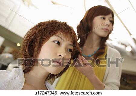 Hairdresser styling young woman's hair View Large Photo Image Stock Photography - Hairdresser styling young woman's hair. Fotosearch