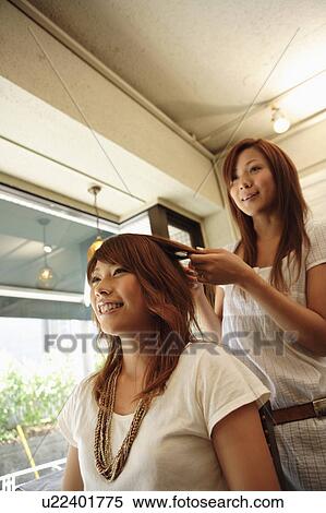 Hairdresser styling young woman's hair View Large Photo Image Stock Photography - Hairdresser styling young woman's hair. Fotosearch