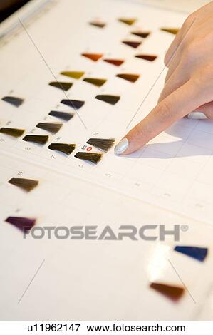 Stock Photo - Woman selecting color of hair dye. Fotosearch