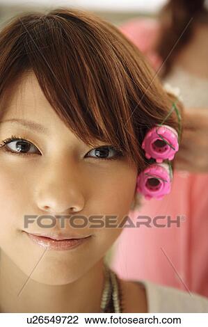 Stock Image - Young woman having hair curled. Fotosearch