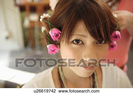 Stock Image - Young woman having hair curled. Fotosearch