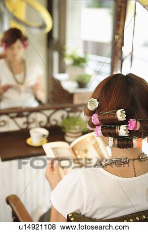 Stock Photo - Young woman having hair curled. Fotosearch