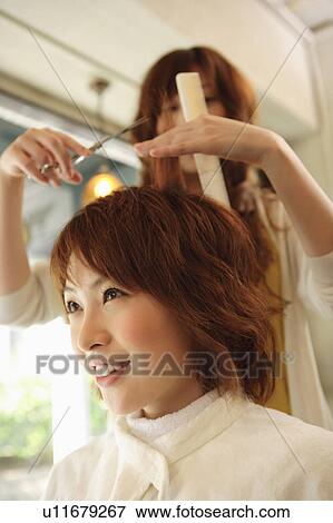 Stock Photo - Young woman having hair cut. Fotosearch