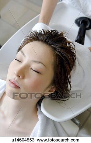 Stock Image - Young woman having hair dried with towel. Fotosearch