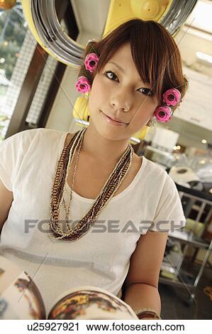 Stock Image - Young woman having hair permed. Fotosearch