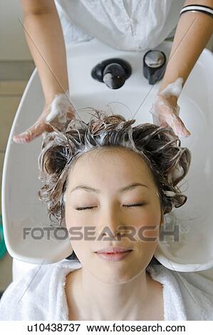 Stock Photo - Young woman having hair washed. Fotosearch