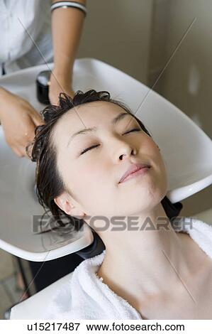 Stock Photo - Young woman having hair washed. Fotosearch