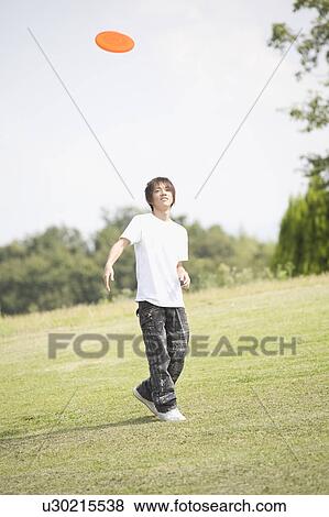 One teenage boy playing with plastic disc View Large Photo Image Stock Photo - One teenage boy playing with plastic disc. Fotosearch