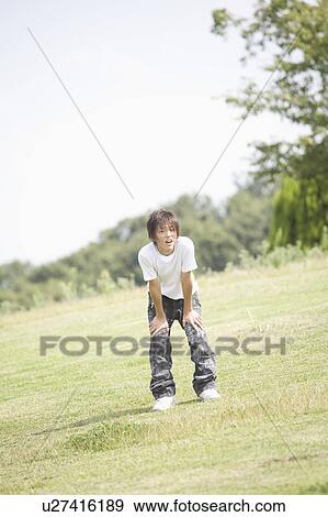 One teenage boy resting with hands on knee View Large Photo Image Stock Photo - One teenage boy resting with hands on knee. Fotosearch