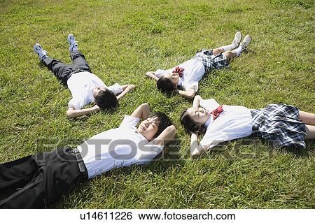 Stock Photograph - School children sleeping in grass field. Fotosearch