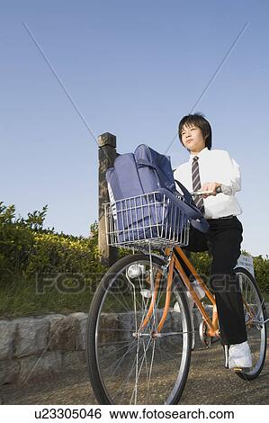 Schoolboy riding bicycle View Large Photo Image Stock Photograph - Schoolboy riding bicycle. Fotosearch
