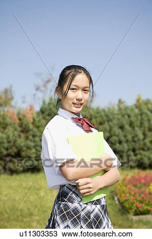 Schoolgirl holding file View Large Photo Image Stock Image - Schoolgirl holding file. Fotosearch