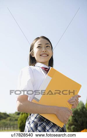 Stock Image - Schoolgirl holding file. Fotosearch