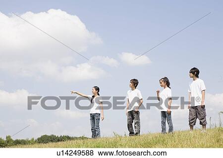 Teenagers standing in grass field View Large Photo Image Stock Photo - Teenagers standing in grass field. Fotosearch