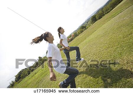 Stock Photography - Two girls running in park. Fotosearch