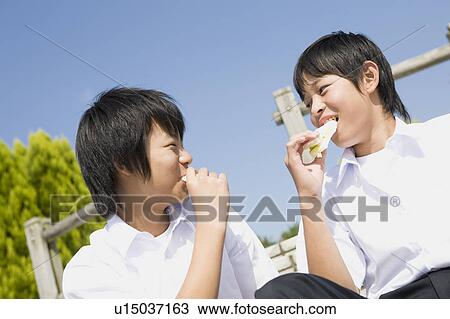 Stock Image - Two schoolboys eating sandwiches. Fotosearch