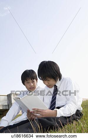 Two schoolboys reading book View Large Photo Image Picture - Two schoolboys reading book. Fotosearch