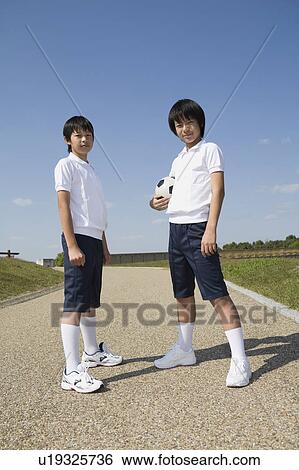Two schoolboys standing with soccer ball View Large Photo Image Stock Photograph - Two schoolboys standing with soccer ball. Fotosearch