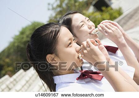 Stock Photo - Two schoolgirls eating sandwiches. Fotosearch