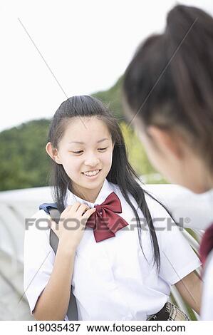 Two schoolgirls talking View Large Photo Image Stock Photo - Two schoolgirls talking. Fotosearch