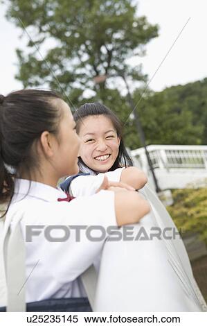 Stock Photography - Two schoolgirls talking. Fotosearch