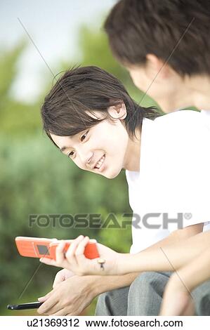 Two teenage boys looking at mobile phones View Large Photo Image Stock Image - Two teenage boys looking at mobile phones. Fotosearch