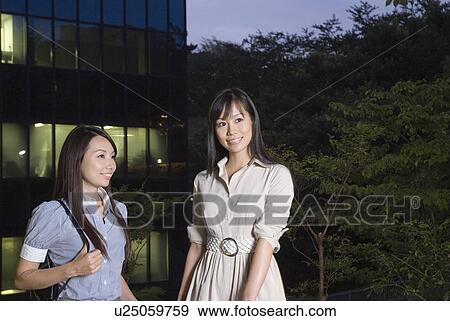 Stock Photo - Two young woman leaving office. Fotosearch