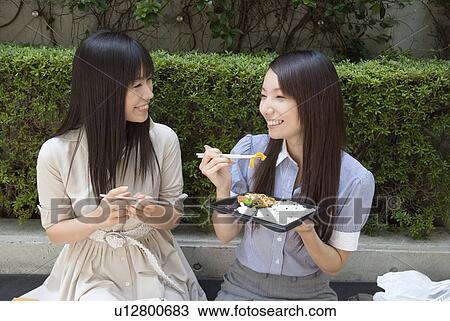 Two young women eating lunch View Large Photo Image Stock Image - Two young women eating lunch. Fotosearch