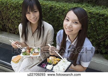 Two young women eating lunch View Large Photo Image Stock Image - Two young women eating lunch. Fotosearch