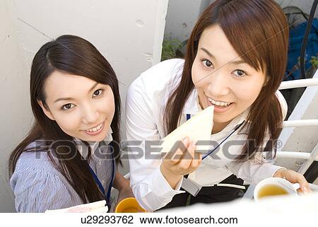 Stock Image - Two young women eating lunch. Fotosearch