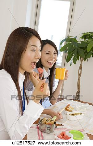 Stock Photo - Two young women eating lunch. Fotosearch
