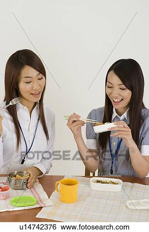 Two young women eating lunch View Large Photo Image Stock Photograph - Two young women eating lunch. Fotosearch