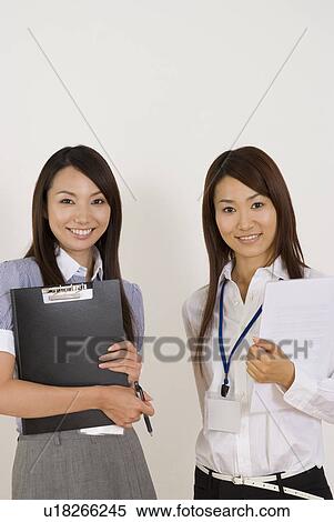 Stock Photography - Two young women standing with files. Fotosearch