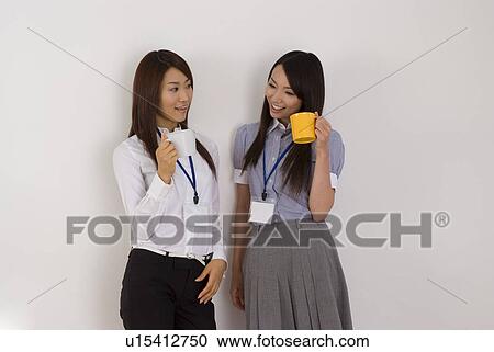 Two young women talking with cup of coffee View Large Photo Image Stock Image - Two young women talking with cup of coffee. Fotosearch