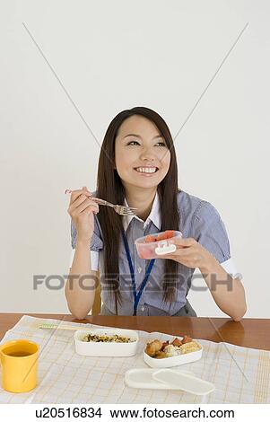 Picture - Young woman eating lunch. Fotosearch