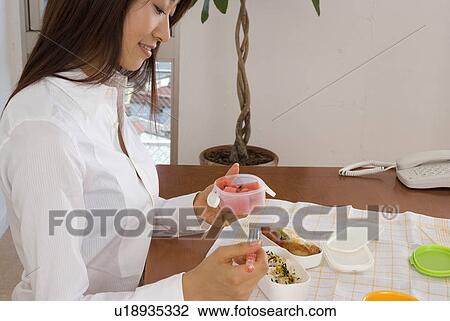 Young woman eating lunch View Large Photo Image Stock Image - Young woman eating lunch. Fotosearch