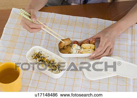 Stock Photograph - Young woman eating lunch. Fotosearch