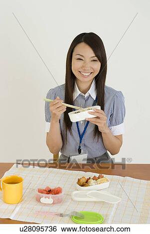 Stock Photograph - Young woman eating lunch. Fotosearch