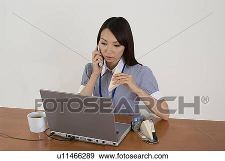 Young woman eating sandwiches at desk View Large Photo Image Stock Photo - Young woman eating sandwiches at desk. Fotosearch