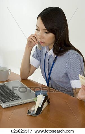Young woman eating sandwiches at desk View Large Photo Image Stock Photo - Young woman eating sandwiches at desk. Fotosearch