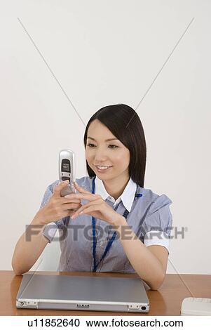 Young woman looking at mobile phone View Large Photo Image Stock Image - Young woman looking at mobile phone. Fotosearch