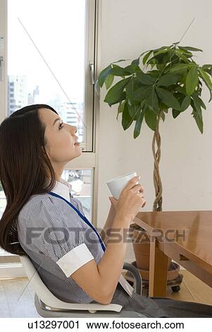 Stock Image - Young woman looking up. Fotosearch