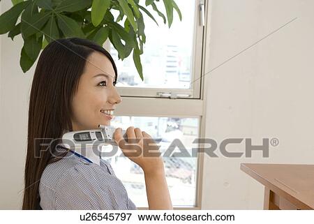 Young woman smiling with mobile phone View Large Photo Image Stock Photo - Young woman smiling with mobile phone. Fotosearch