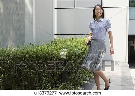 Stock Photo - Young woman walking with wallet. Fotosearch