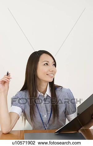 Young woman working in office View Large Photo Image Stock Image - Young woman working in office. Fotosearch