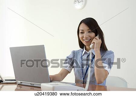 Young woman working in office View Large Photo Image Stock Image - Young woman working in office. Fotosearch